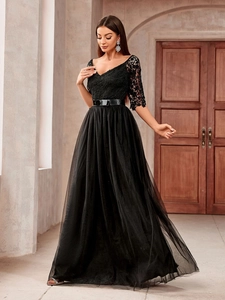 Detail of elegant black V-neck evening gown with lace bodice and tiered mesh skirt
