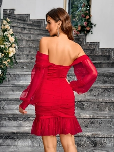 Détail de robe rouge à épaules dénudées avec perles et manches bouffantes en mesh