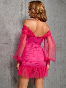 Détail de robe fuchsia à épaules dénudées avec manches bouffantes et perles brodées