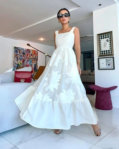 Détail de robe longue blanche avec appliques florales 3D et décolleté carré élégant raffiné