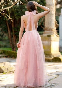 Detail of light pink mesh dress featuring a large back bow and elegant long ribbons