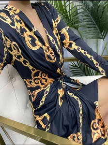 Detailed view of the deep V-neckline and elegant baroque chain print on the long sleeve dress