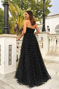 Close-up of black strapless dress featuring colorful sequins and multi-layer mesh fabric