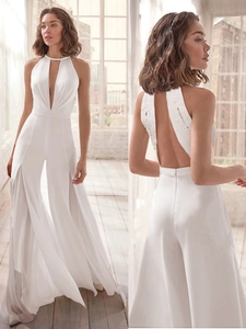 Detail of white deep V-neck halter jumpsuit with lace stitching and wide-leg tulle pants