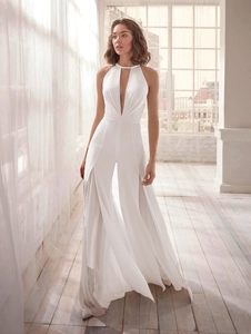 Detailed view of the elegant pearl halter neckline and deep V-neck on the white jumpsuit