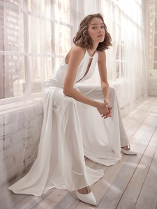 Detail of elegant white halter bridal jumpsuit with pearls and long flowing train