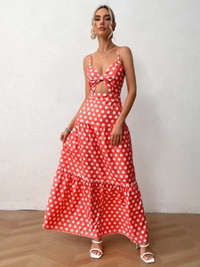 Detail of red polka dot summer dress with bow neckline and waist cutout accents