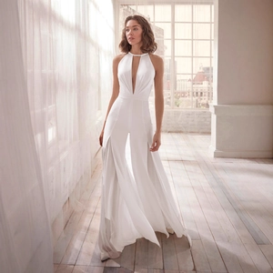 Elegant white halter neck jumpsuit with deep V-neckline and flowing wide-leg trousers