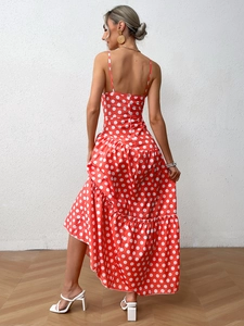 Detail of red polka dot dress with tiered ruffles and asymmetric hem on white background