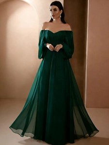 Detail of elegant dark green off-shoulder evening dress with lantern sleeves and flowing skirt