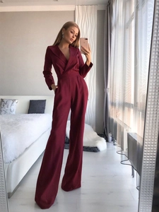 Detail eines burgunderroten Langarm-Jumpsuits mit V-Ausschnitt und weitem Bein