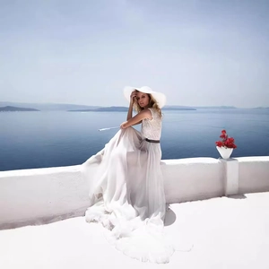 Elegant white lace sleeveless chiffon maxi dress with a wide-brimmed straw hat for resort