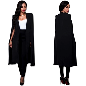 Détail d'un blazer long noir style cape avec manches fendues et coupe structurée élégante