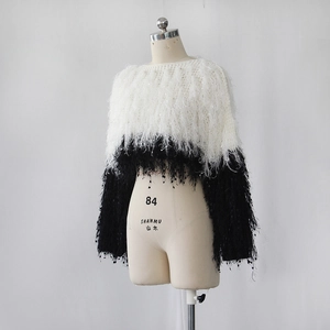 Close-up of black and white color block knit sweater with long fringe trim details