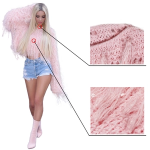 Vue détaillée du pull en tricot rose avec de longues franges et des plumes décoratives