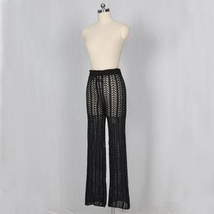 Détail du pantalon en maille crochet noir à taille haute et motifs géométriques