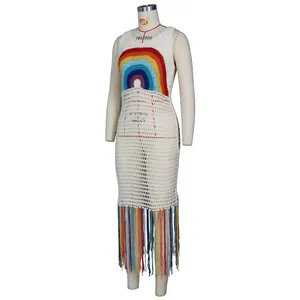 Détail d'une robe blanche au crochet avec motif arc-en-ciel et pompons à franges colorés