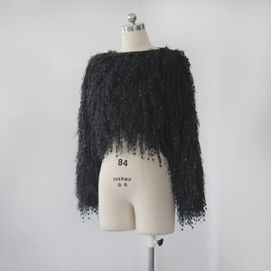 Detail of black knit sweater with dense fringe tassels and shimmering sequin accents