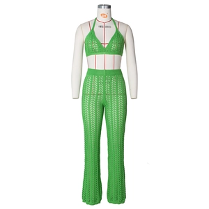Detail of green crochet knit two-piece set featuring halter top and hollow-out pants