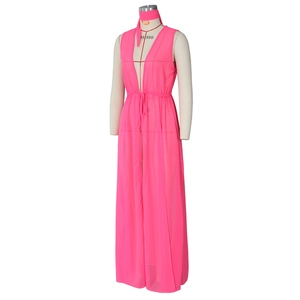 Détail d'un cache-maillot maxi en mousseline rose vif avec col en V et taille à cordon de serrage