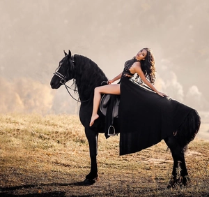Detailed view of sexy black lace halter dress with high slit on a model riding a horse