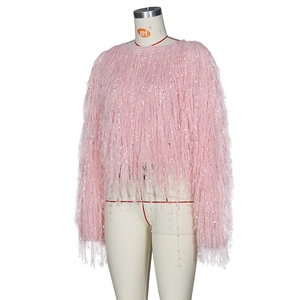 Détail du pull en maille rose montrant des franges de plumes et sequins brillants