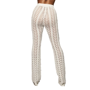 Détail du pantalon en maille crochet blanc avec motifs en V évidés et taille haute évasée