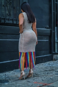 Gros plan sur une robe de plage blanche au crochet avec de longs pompons arc-en-ciel