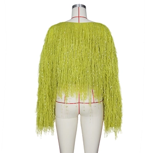 Détail d'un pull en tricot vert citron avec de longues franges et paillettes argentées