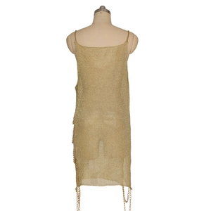 Détail de la robe en maille dorée avec dos nu et finitions en franges métalliques