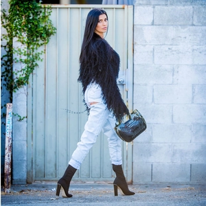 Chic women's black plush knit sweater paired with ripped jeans and stiletto boots