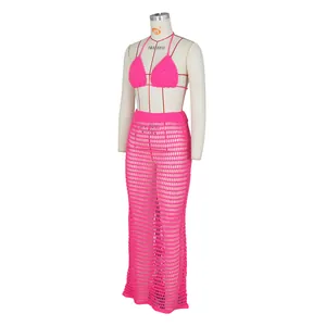 Close-up of bright pink crochet two-piece set featuring a halter top and hollow out maxi skirt
