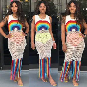 Détails d'une robe de plage blanche au crochet avec motif arc-en-ciel et longues franges