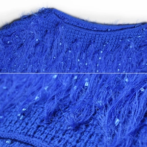 Vue macro détaillée du pull en tricot bleu roi avec poils longs et paillettes bleues