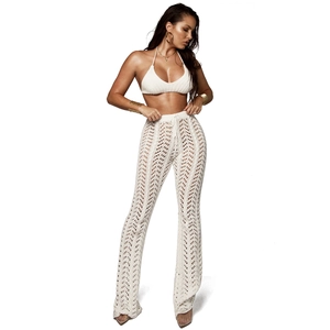 Vue détaillée du motif en crochet blanc sur le pantalon de plage ajouré et le haut assorti