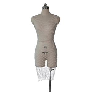 Détail de la robe en maille blanche avec perles scintillantes et texture ajourée en col V