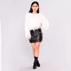 Detail of white plush knit sweater paired with a black leather mini skirt and side zipper
