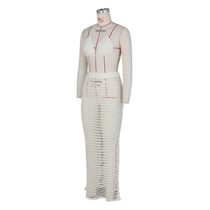 Detail of white crochet knit two-piece beach set featuring mesh texture and handmade patterns