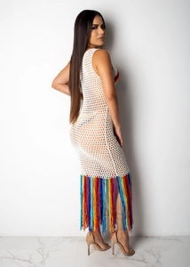 Détail de la robe en crochet blanc avec des franges arc-en-ciel colorées sur le bas