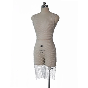 Détail de la robe en maille perlée blanche avec motif losange et décolleté en V profond