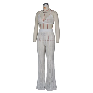 Detail of white crochet knit two-piece set featuring hollow patterns and flared trousers
