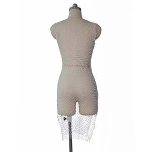Détail de la robe en maille blanche avec perles montrant le motif en losange et dos en V