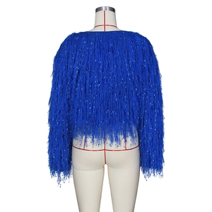 Détail d'un pull en maille bleu avec de longues franges et des paillettes bleues brillantes
