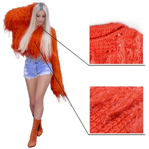 Détail d'un pull en maille orange tendance avec des textures de franges faites à la main