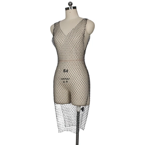Détail de la robe en maille résille noire avec strass argentés et décolleté en V profond