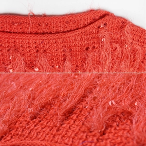 Vue macro détaillée du pull en maille rouge orangé avec fil de cils doux et texture dense