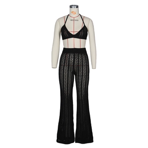 Detail of black crochet knit two-piece set featuring halter top and hollow out flared pants