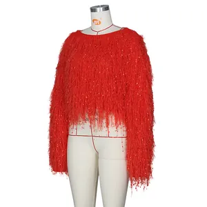 Détail du pull rouge à franges avec paillettes brillantes et maille texturée pour les fêtes