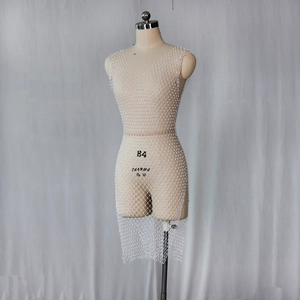 Vue détaillée de la robe en maille blanche avec perles brodées et double décolleté en V