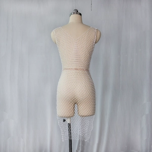 Détail de la robe en résille blanche avec perles incrustées et col en V plongeant